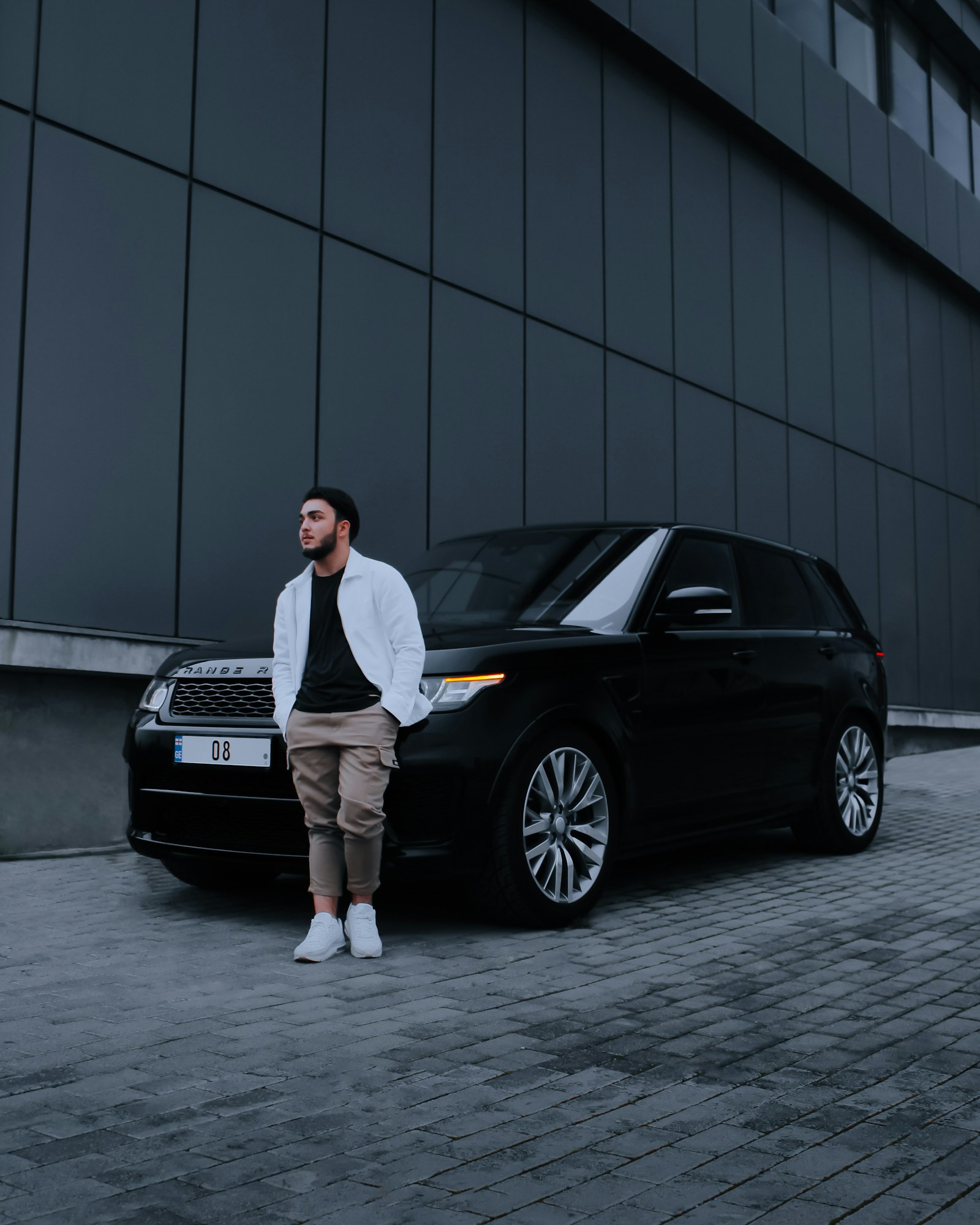 Chauffeur standing beside a black executive vehicle