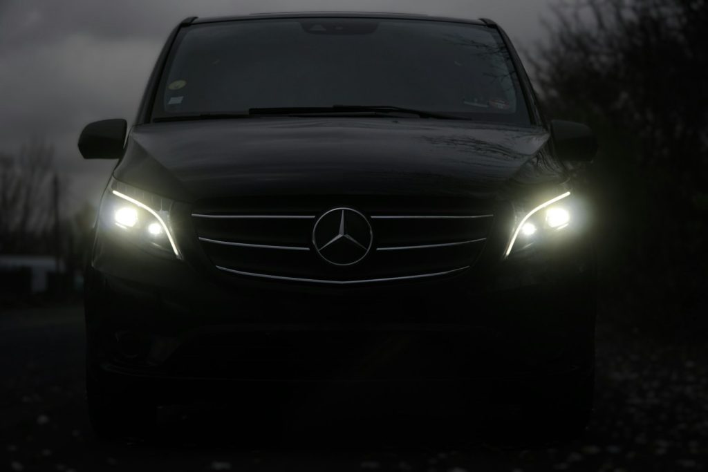 Black Mercedes V-Class MPV with headlights on
