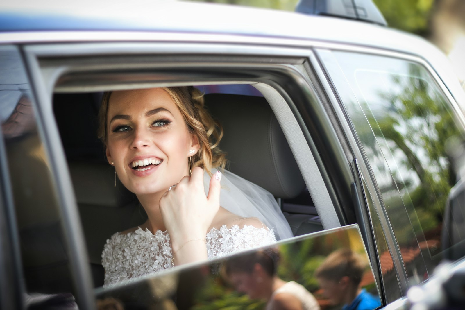 Bride smiling inside a wedding chauffeur car